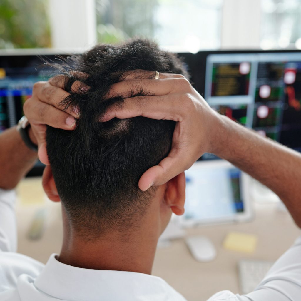 Stock trader tearing out his hair in frustration after loosing money of his clients
